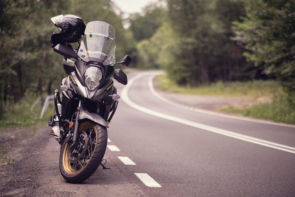 Photo of a Motorcycle with a Helmet on the Handle on the Side of the Road.