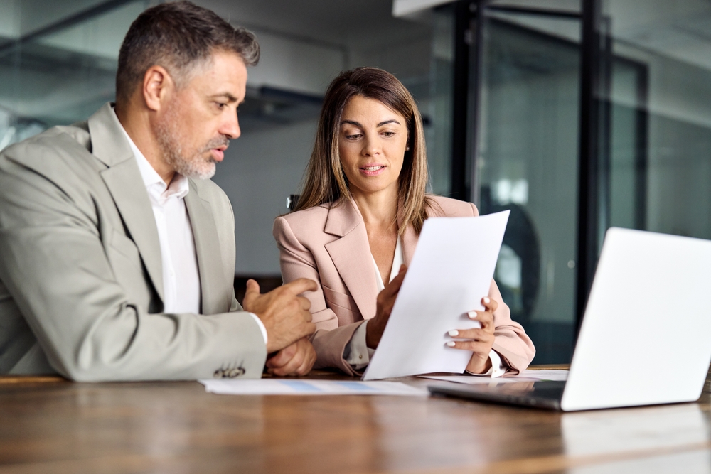 Business professional reviewing workers' compensation insurance documents in an office.